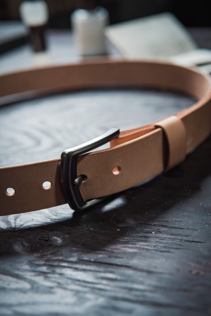 Natural vegetable tanned leather belt, with gun metal gray belt buckle and chicago screws made by Black Flag Leather Goods